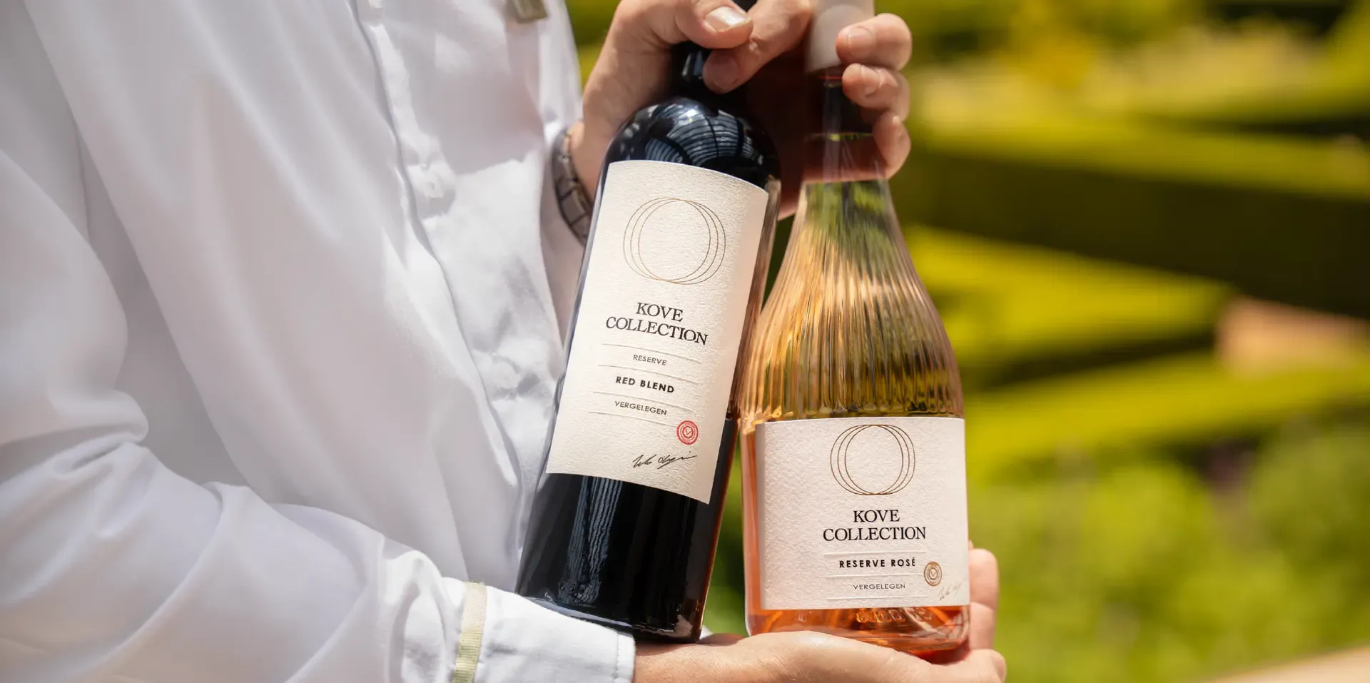 Kove Collection reserve rosé and reserve red blend being held by someone together