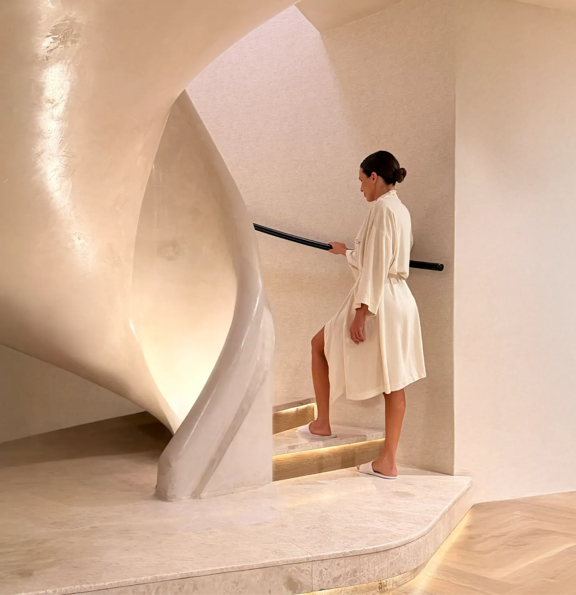 Spa at The Cole girl walking up spiral staircase