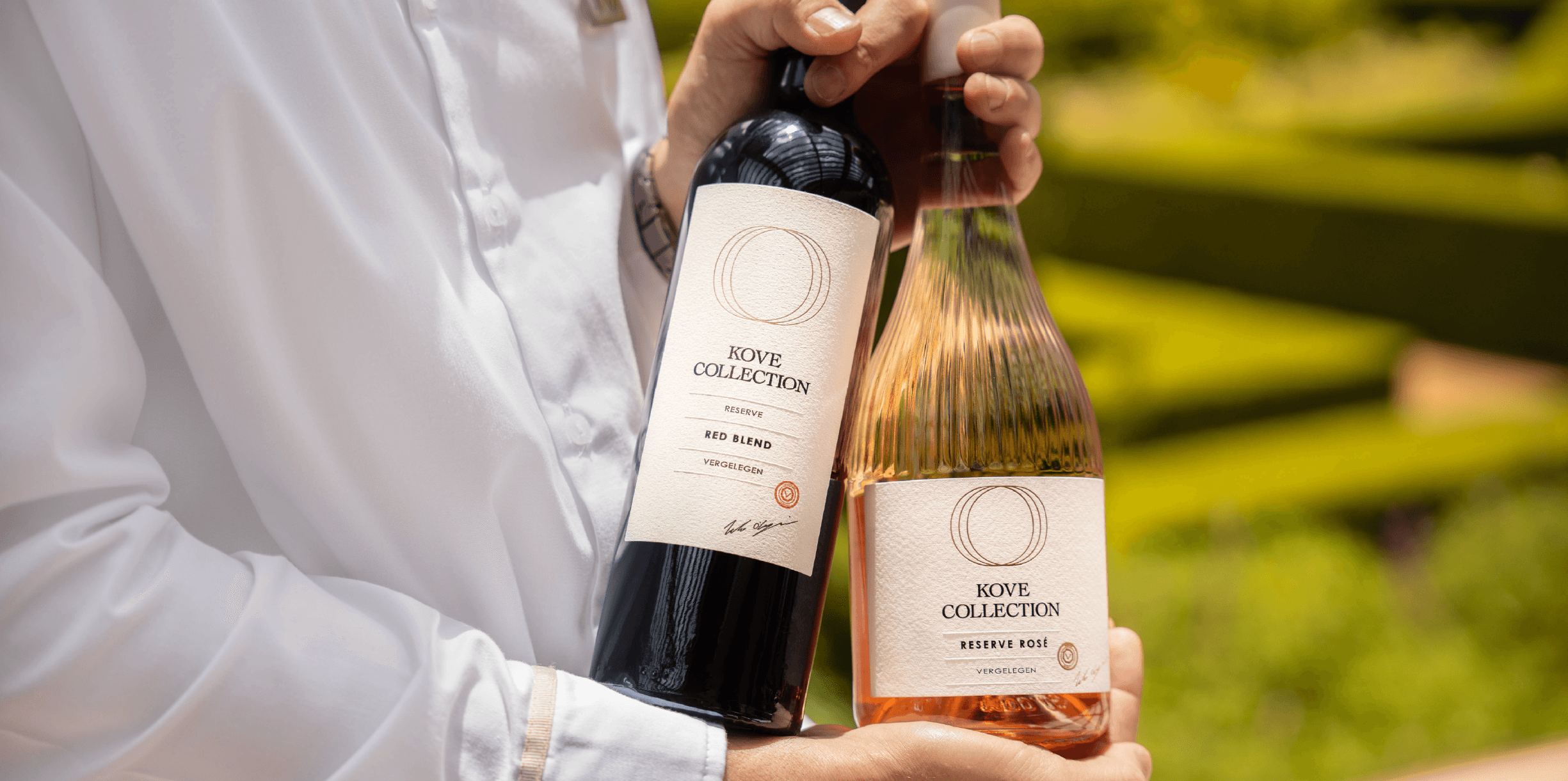 Kove Collection reserve rosé and reserve red blend being held by someone together